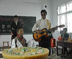 ギターと歌の腕前を披露する教師と児童